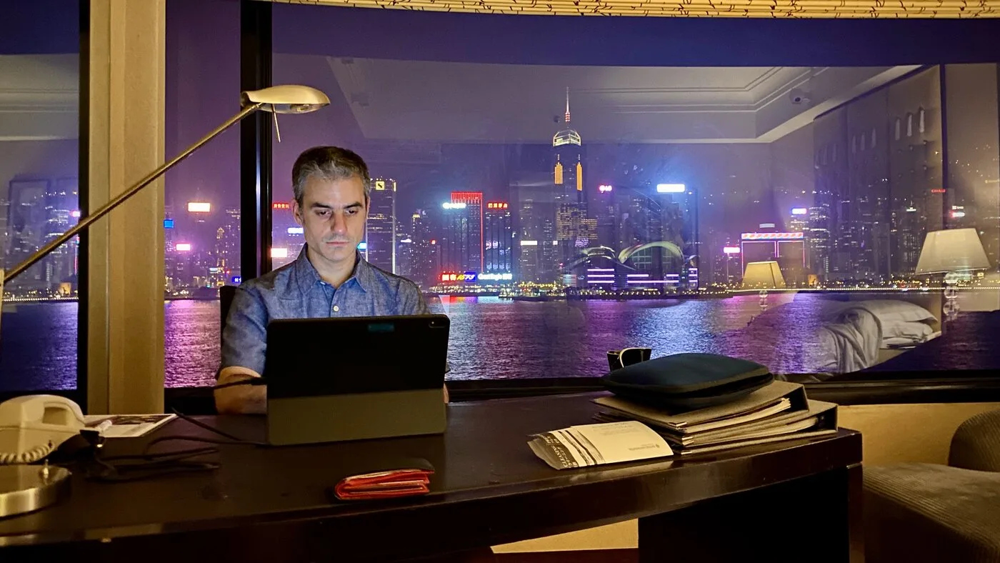 Working late at a hotel desk with a city skyline at night